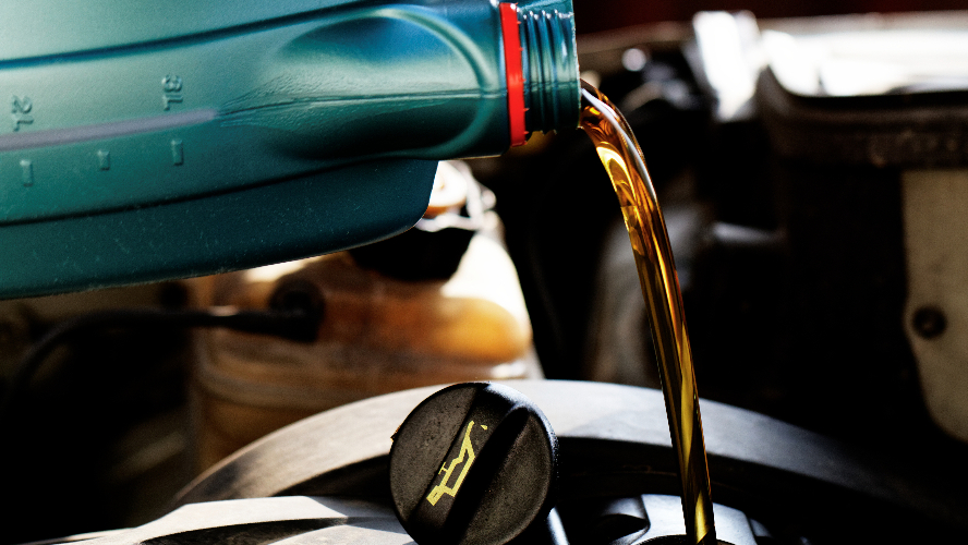 Motor oil being poured into a vehicle during service