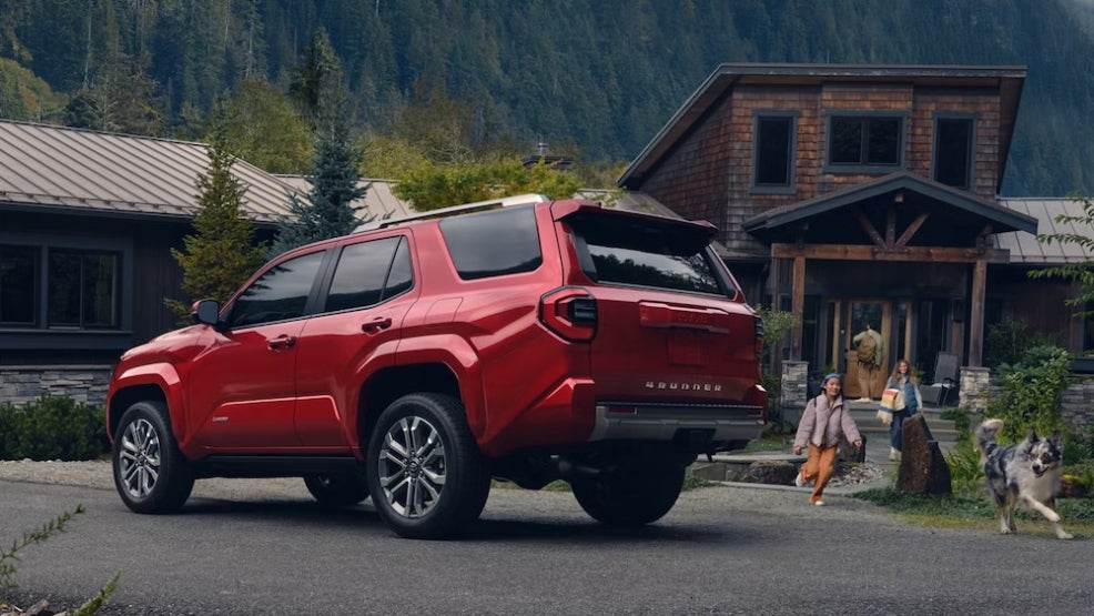 A red 2026 Toyota 4Runner parked outside a cabin