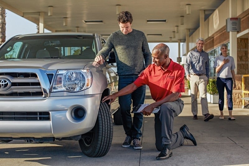 image of a man checking a tire